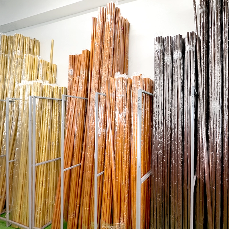 Drevené garnížové  tyče v rôznych odtieňoch dreva, usporiadané v sklade 